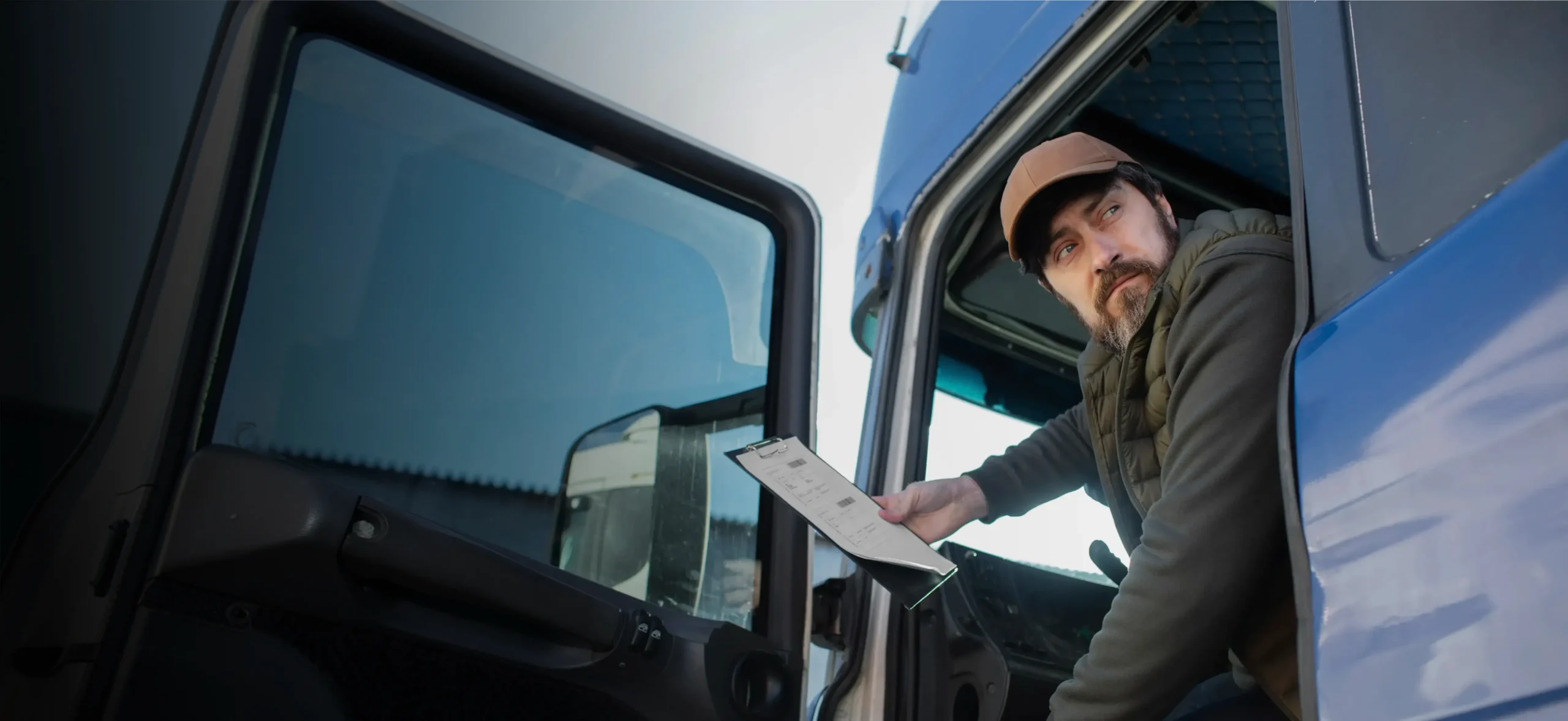 Truck driver checking a tablet from the cab