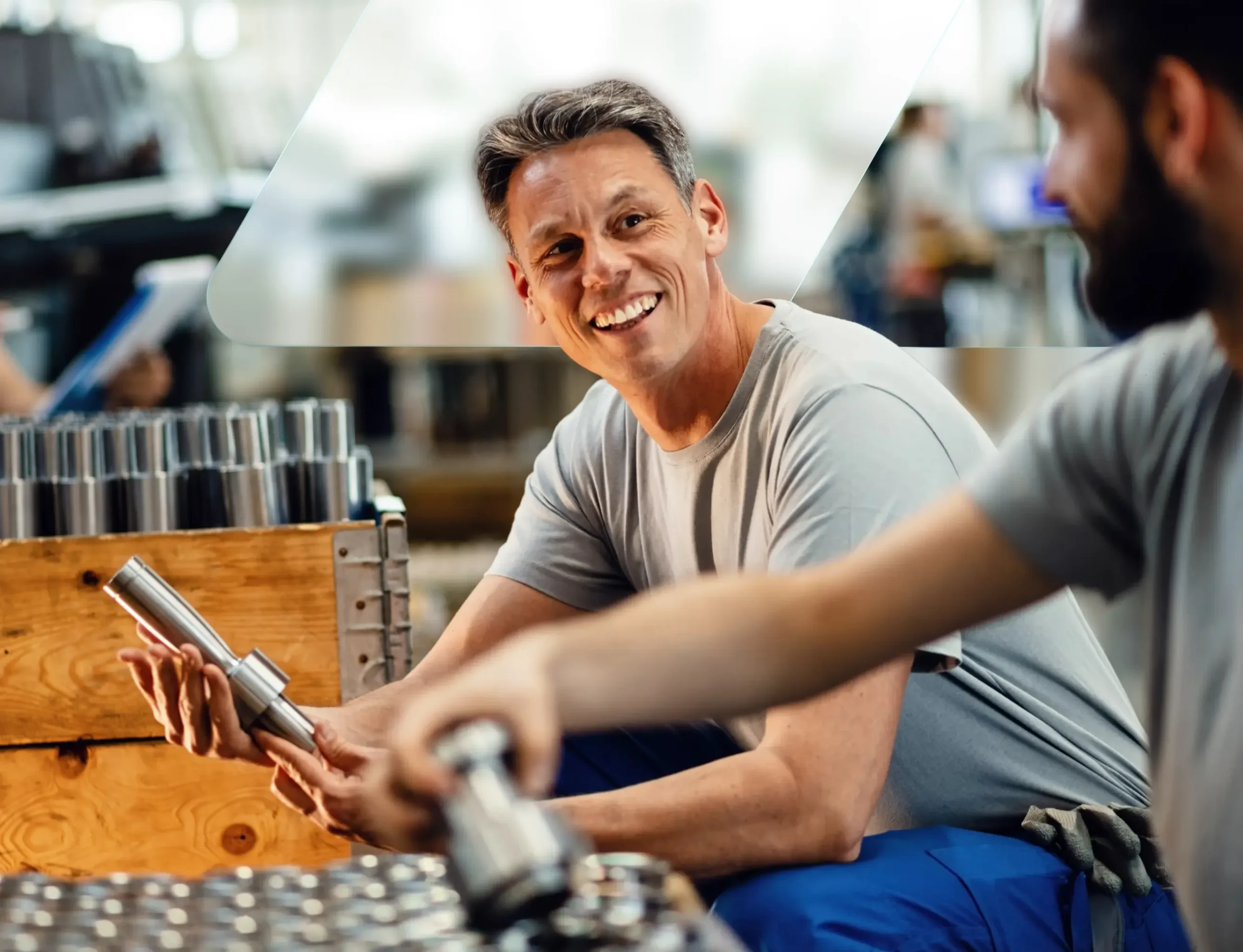 Two manufacturing workers inspecting machined metal parts