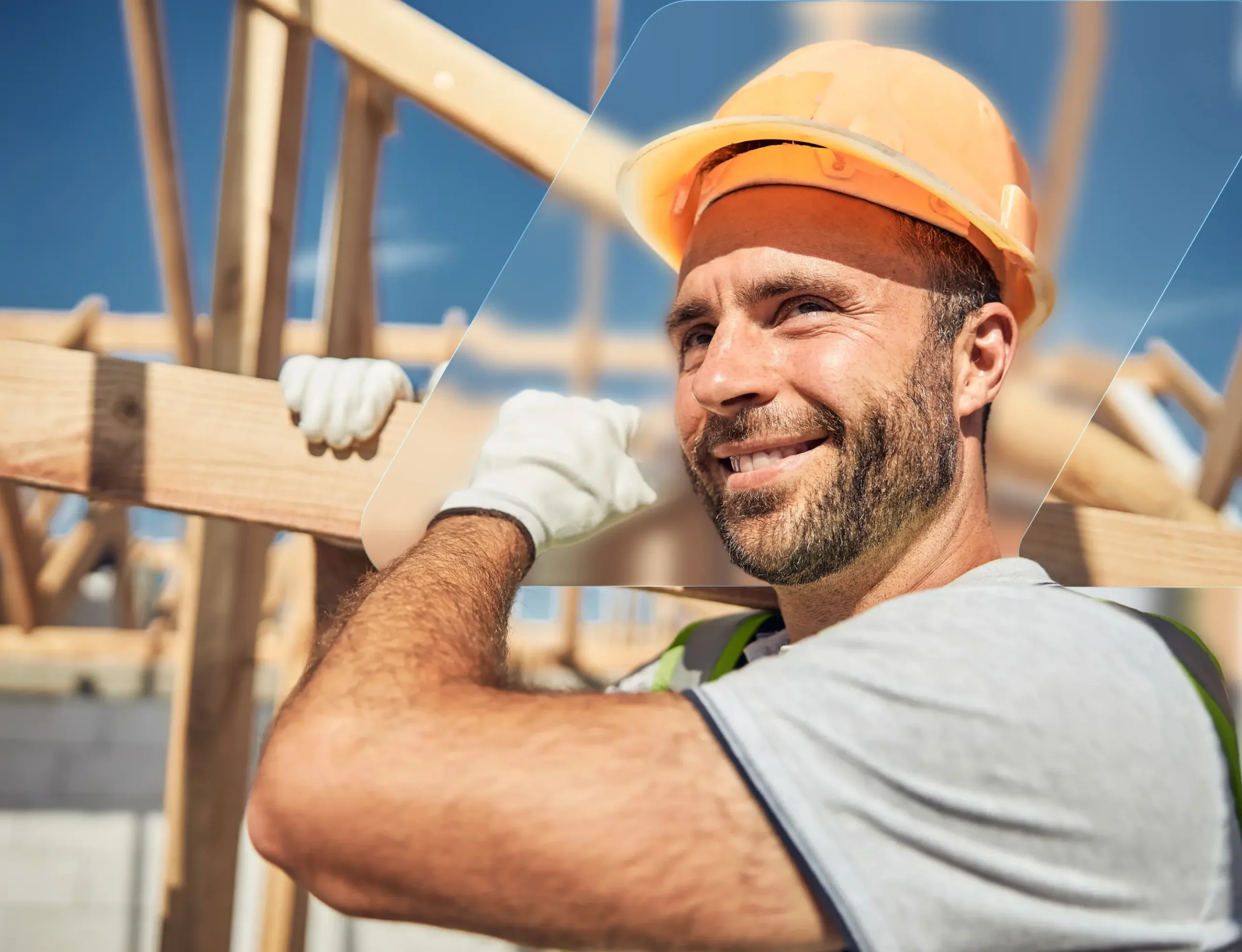 Roofer in a hard hat carrying lumber on a job site