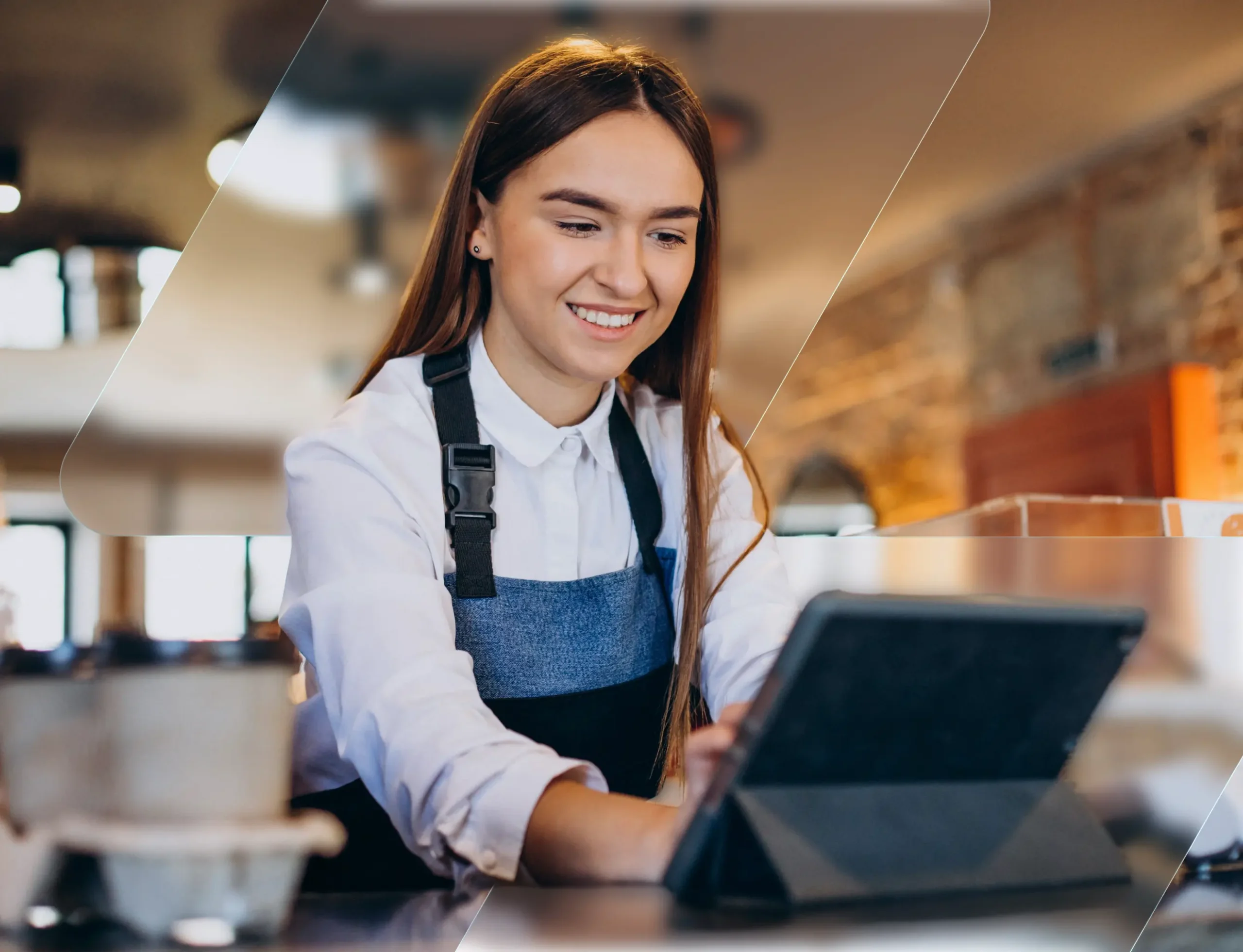 Restaurant owner smiling while using a tablet at the counter