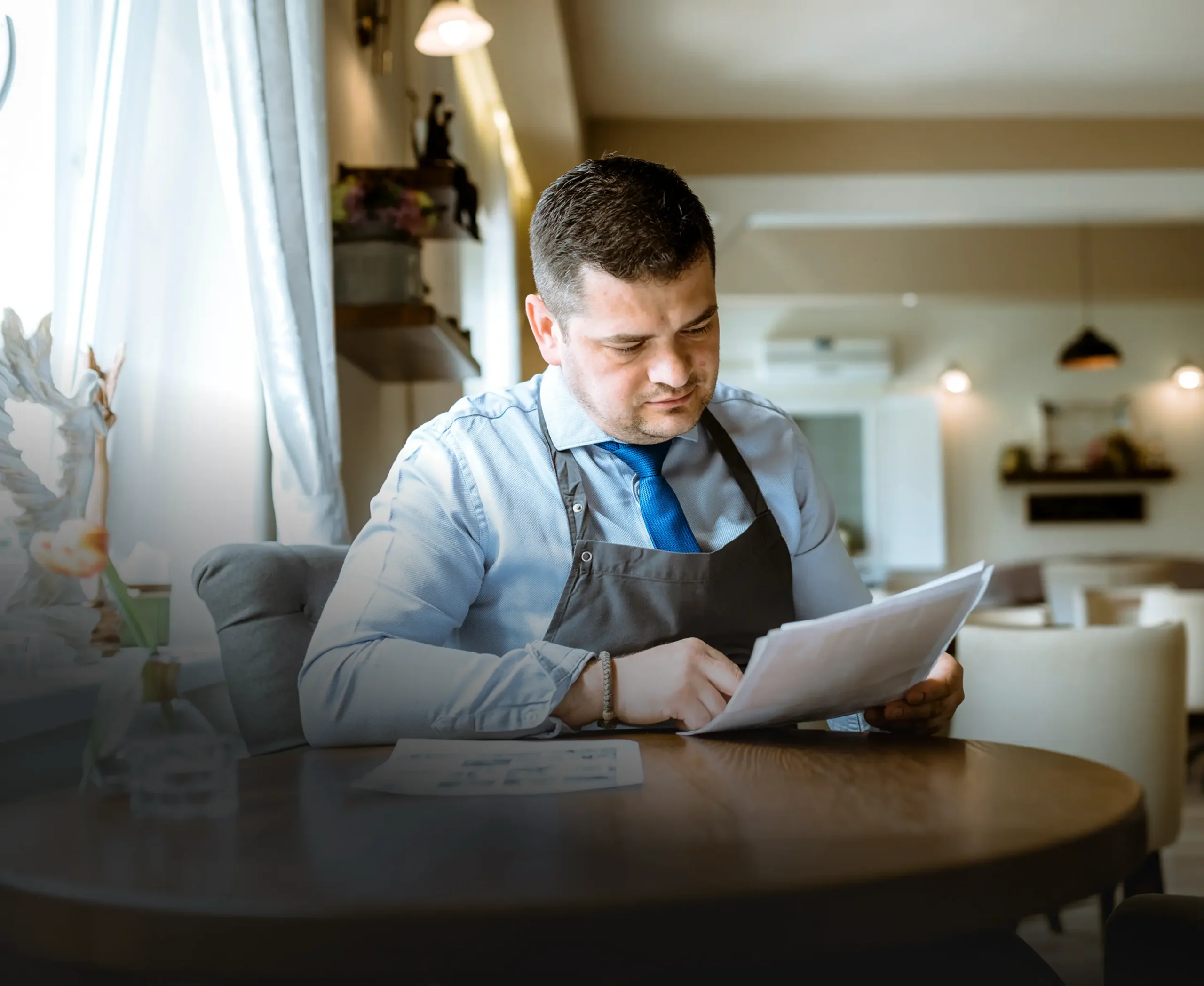 Restaurant owner reviewing paperwork at a dining table