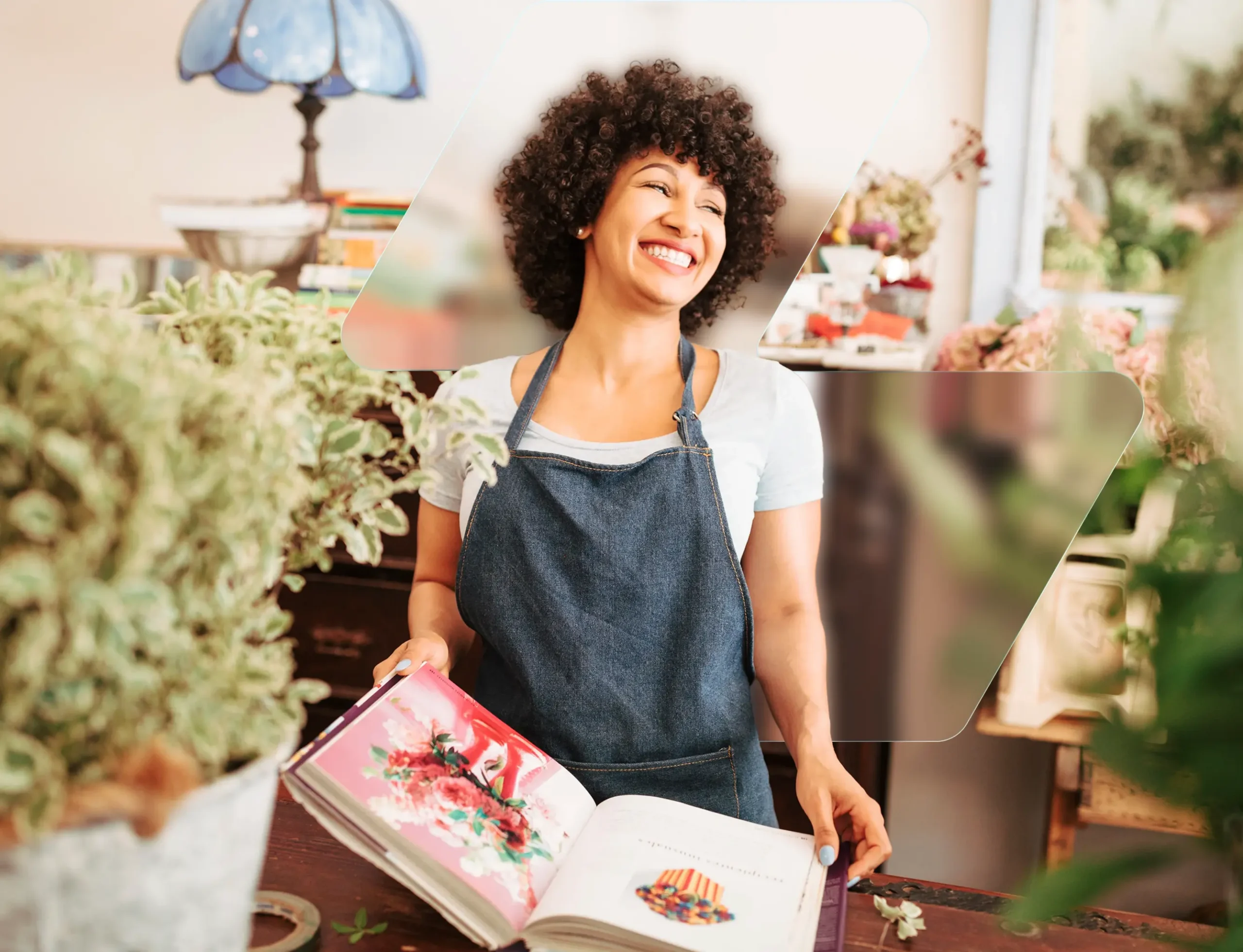 Shop owner in an apron smiling behind the counter of a plant and gift store