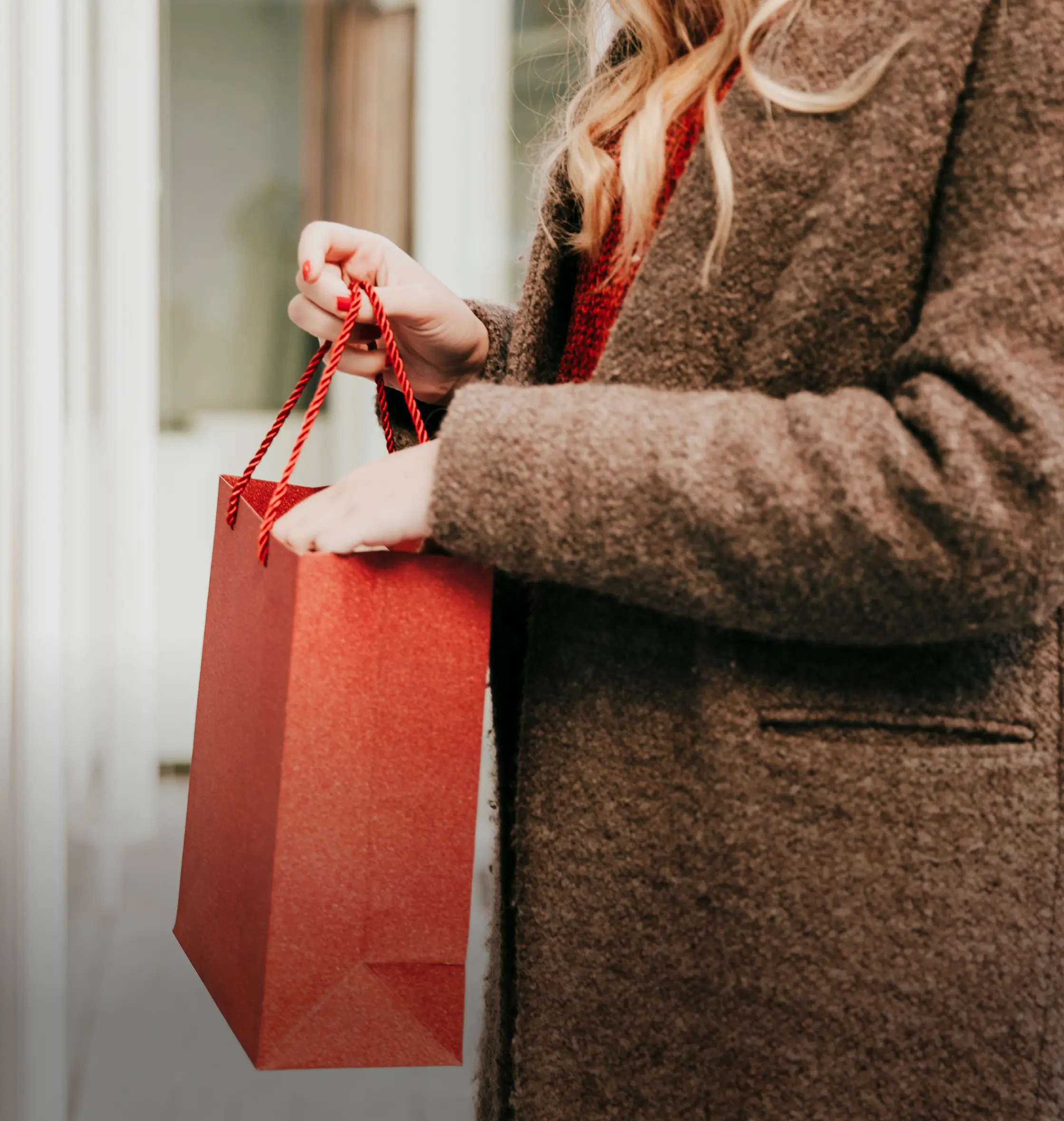 Shopper carrying a red shopping bag