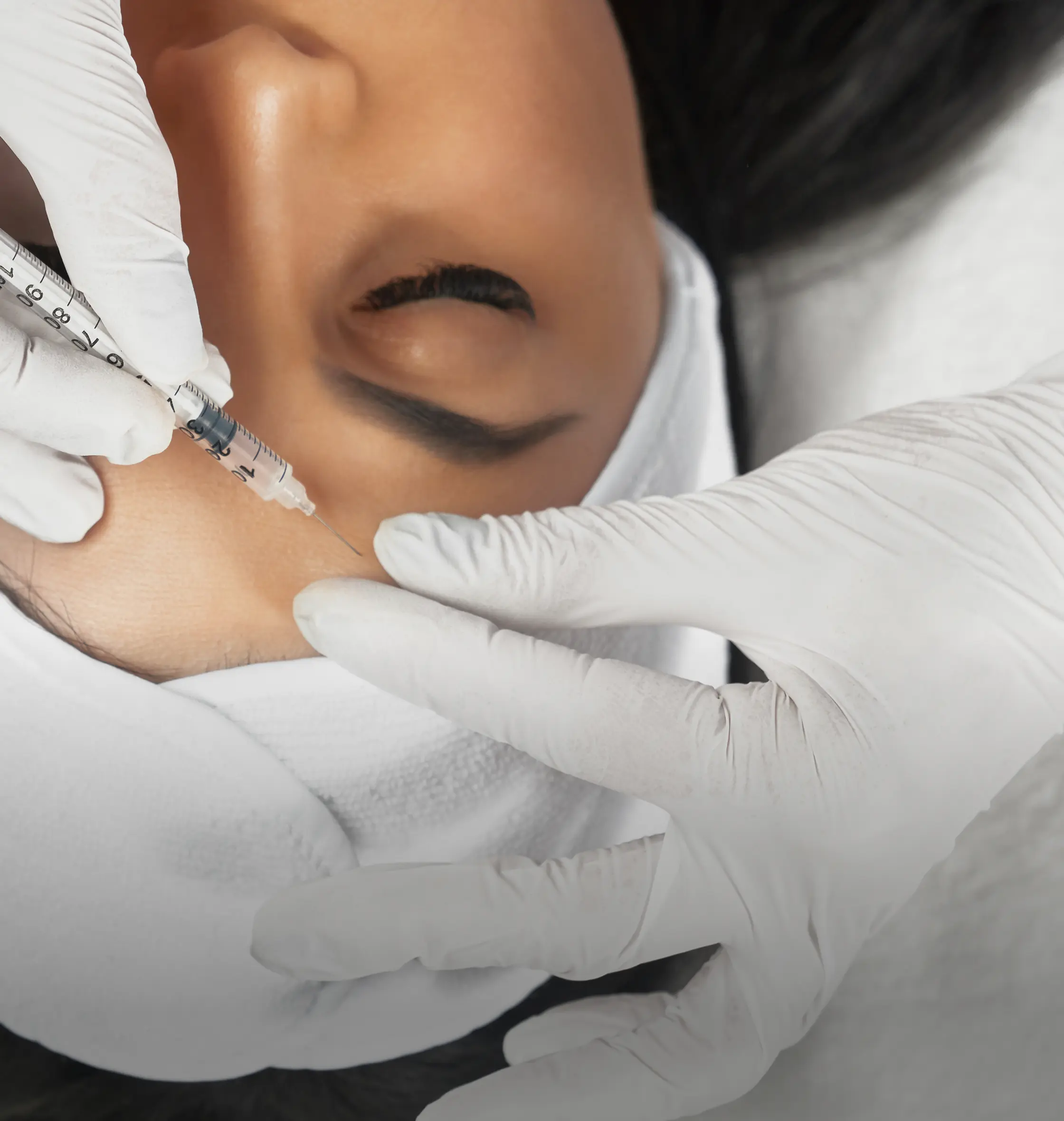 Esthetician performing a cosmetic treatment with gloved hands