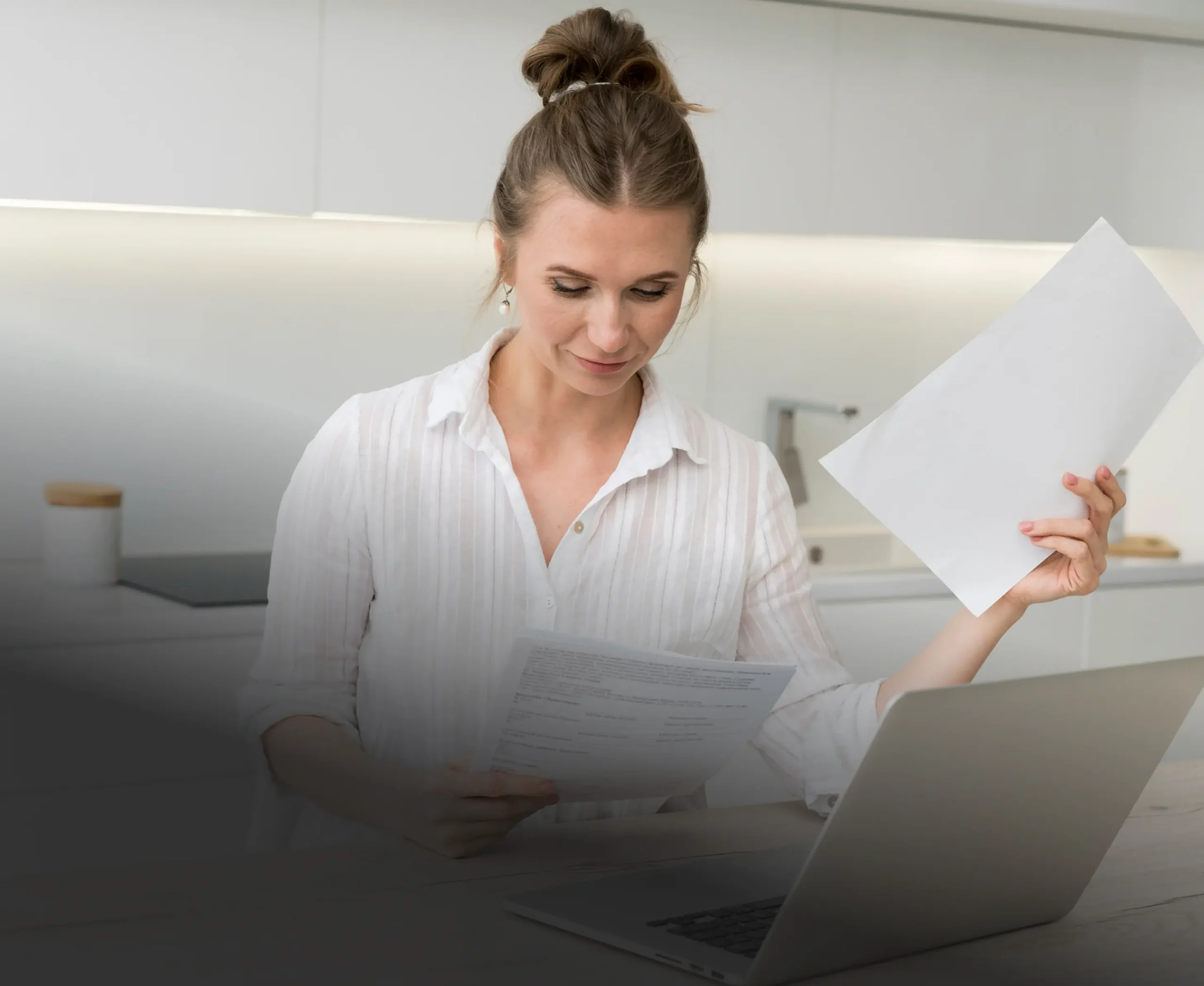 Salon owner reviewing paperwork at her laptop