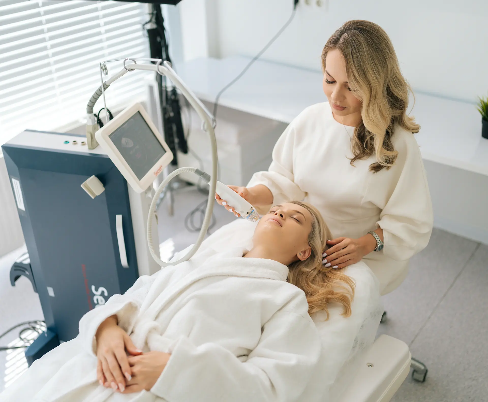 Aesthetician performing a facial treatment on a client with a handheld device in a spa clinic