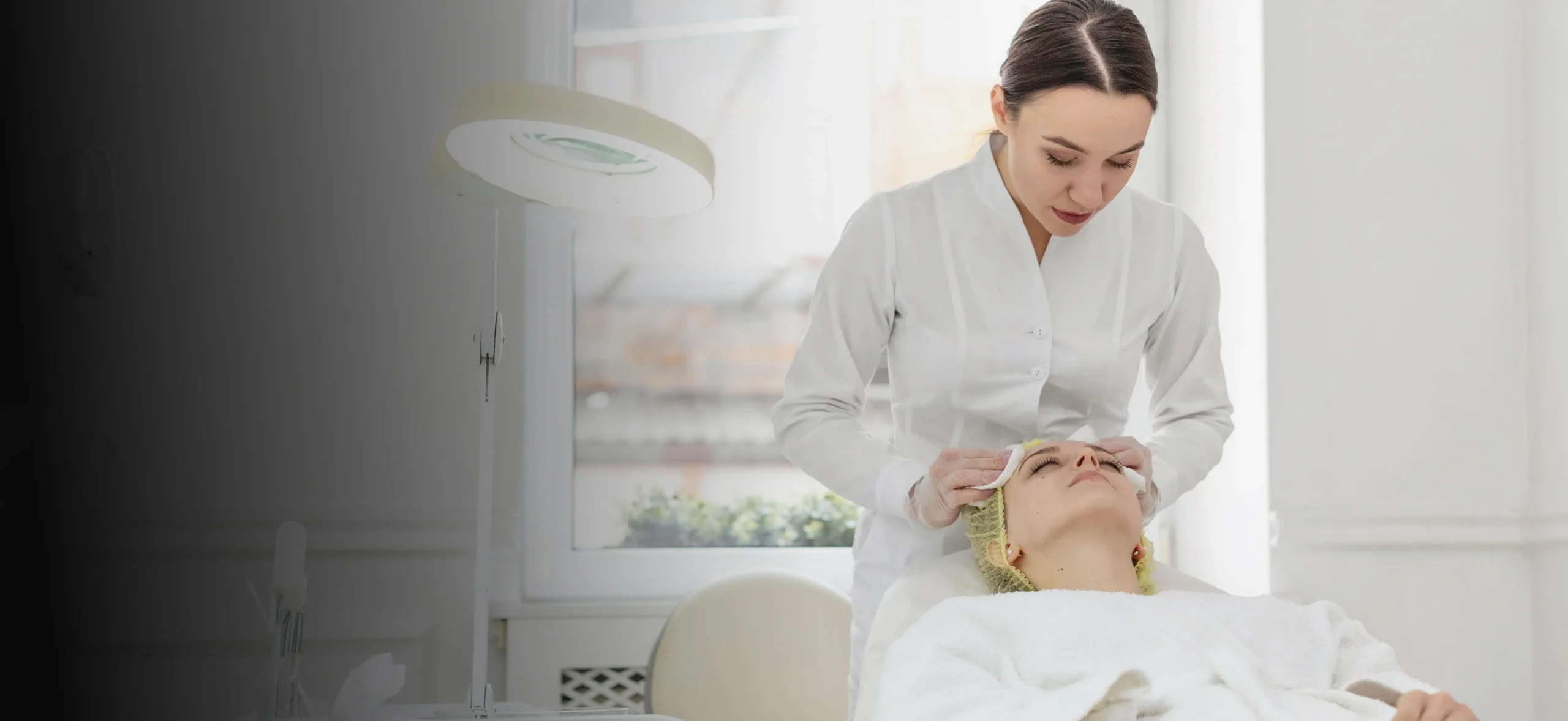 Esthetician preparing a client for a facial