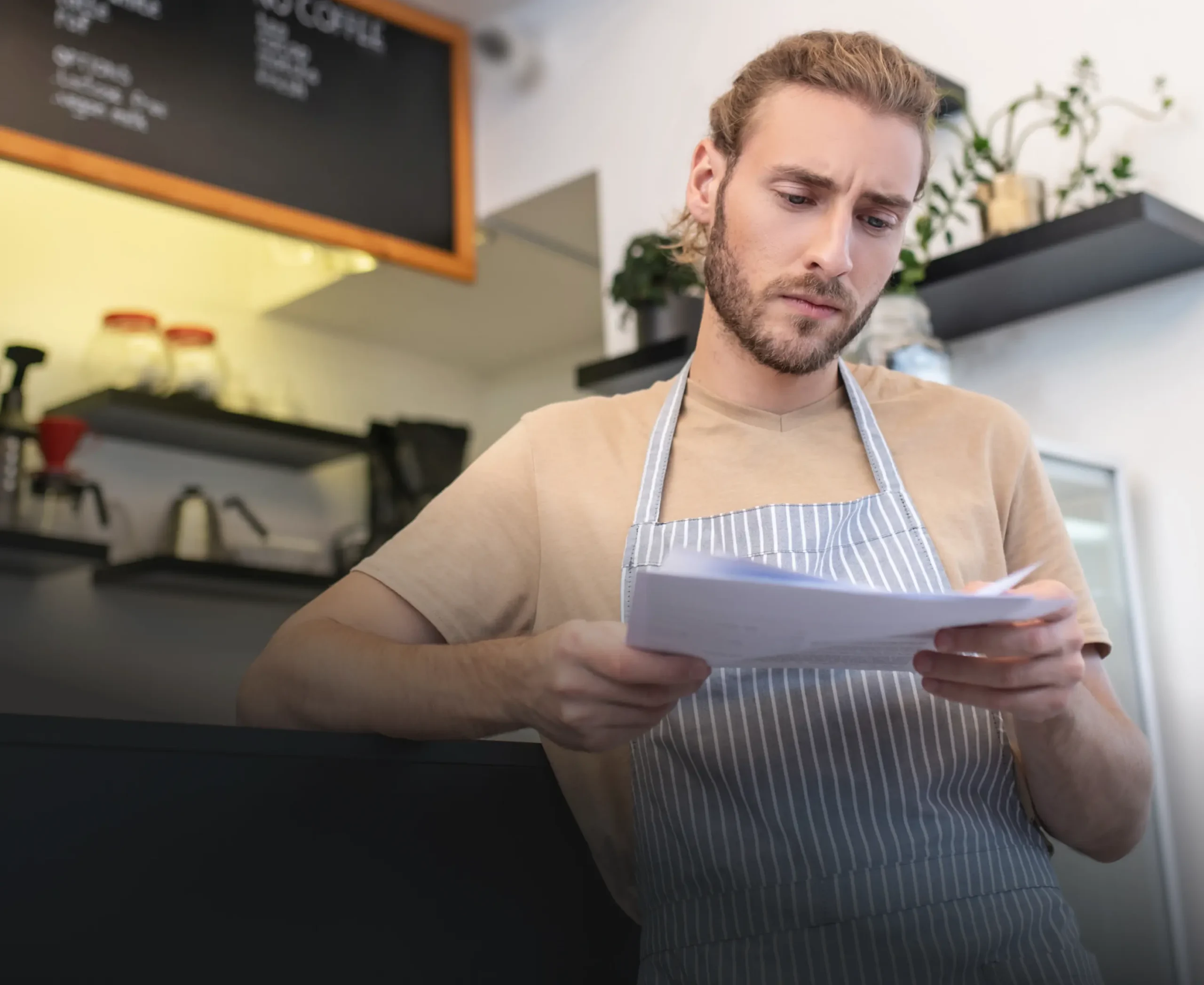 Food truck owner in an apron reviewing paperwork