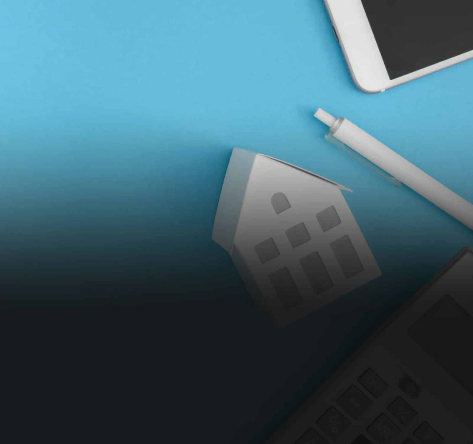 Model house next to a calculator and pen