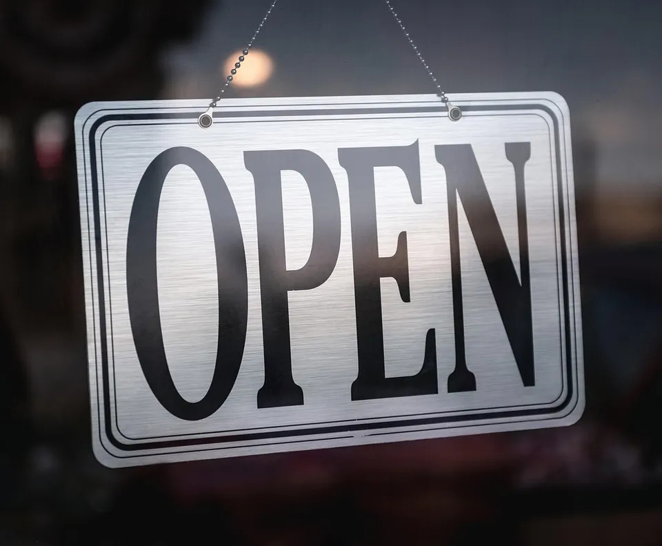 Open sign hanging in a shop door