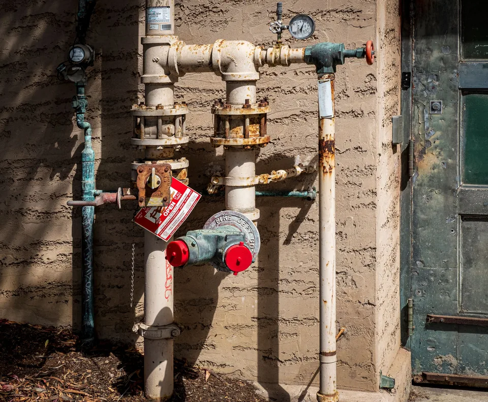 Commercial water service pipes and valves on a building wall