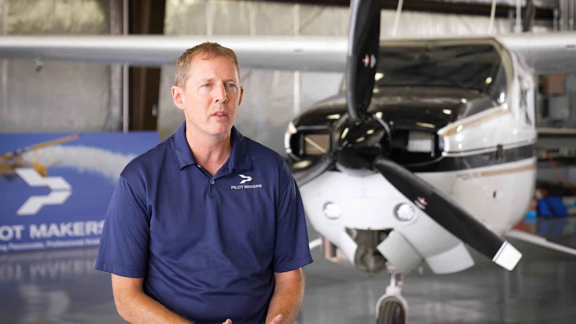 Owner of Pilot Makers Advanced Flight Academy in the hangar beside a training plane