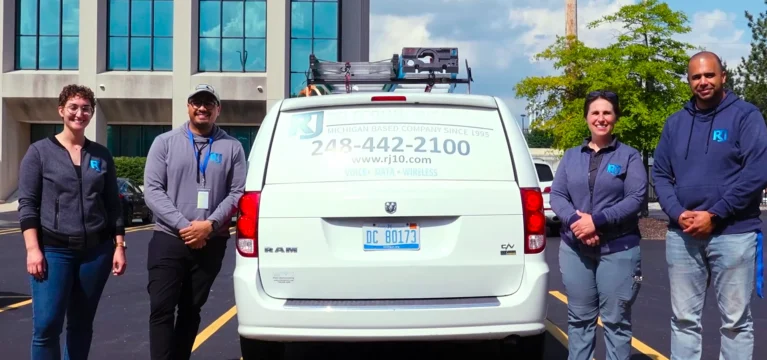 The RJ Telecommunications team beside their service van in Detroit