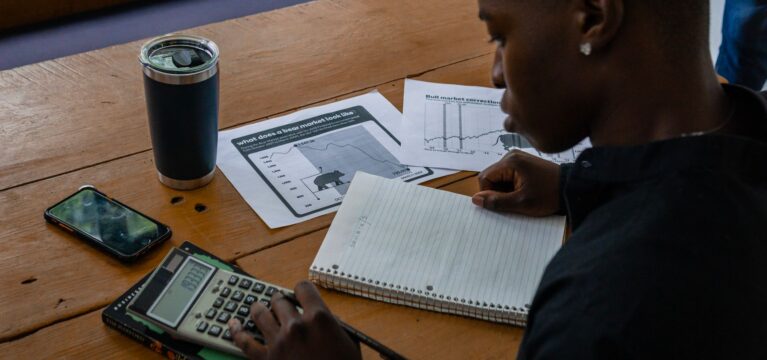 Small business owner working through financing costs with a calculator and notes