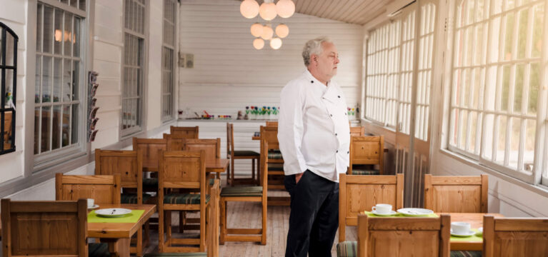 Restaurant owner standing in his empty restaurant.