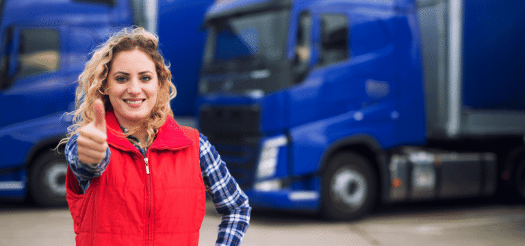 Smiling woman with thumbs up on a background of blue trucks