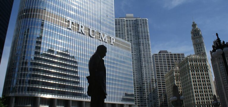 Silhouette in front of Trump Tower Chicago reflecting skyline, symbolizing uncertainty around Trump's new tariff plan.