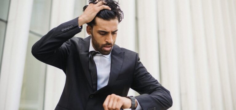stressed man in suit looking at watch
