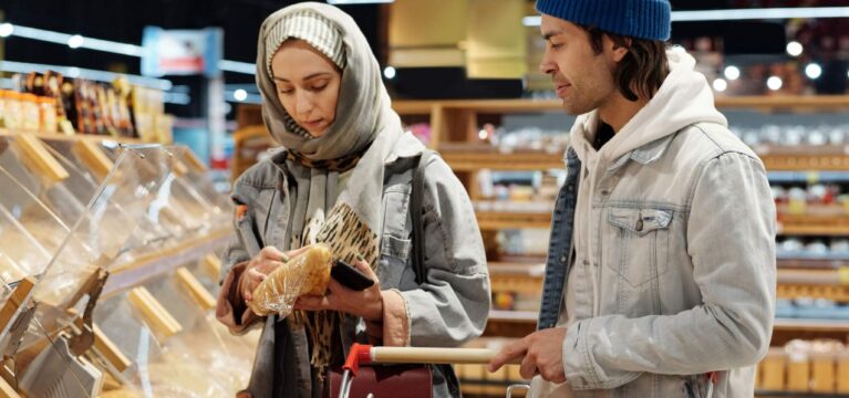 Couple selecting bread in a modern supermarket while grocery shopping together.